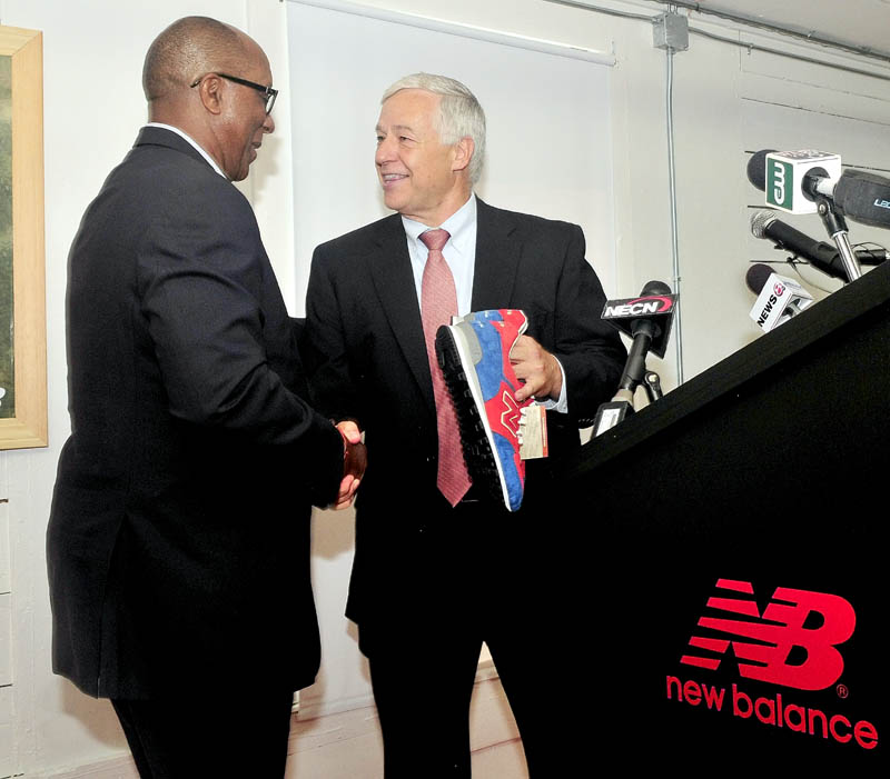 U.S. Rep. Mike Michaud, right, gives U.S. Trade Representative Ambassador Ron Kirk a pair of New Balance shoe company sneakers on behalf of the company during a tour of the facility in Norridgewock on Sept. 13.