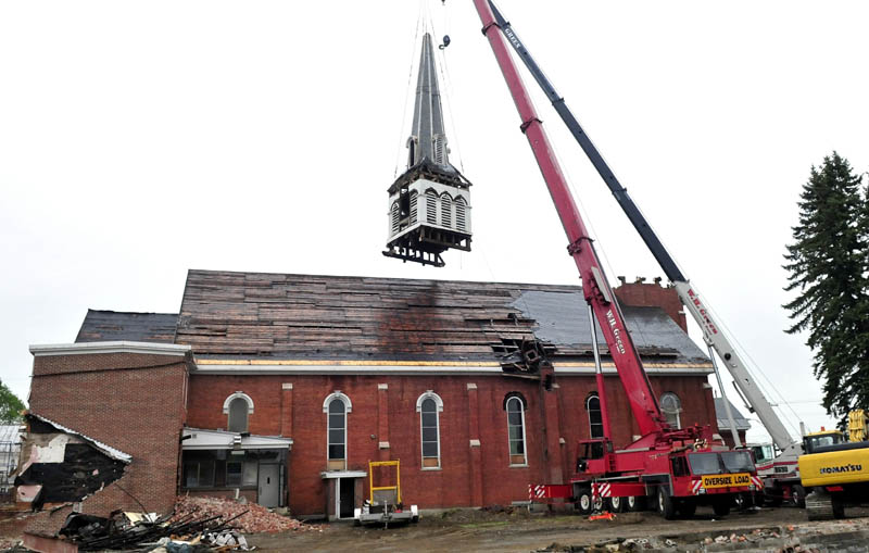 The W. H. Green & Sons crane company brought in a second crane to successfully remove the steeple from the St. Francis de Sales Catholic Church in Waterville on Wednesday. The church is being torn down to make way for a housing project.