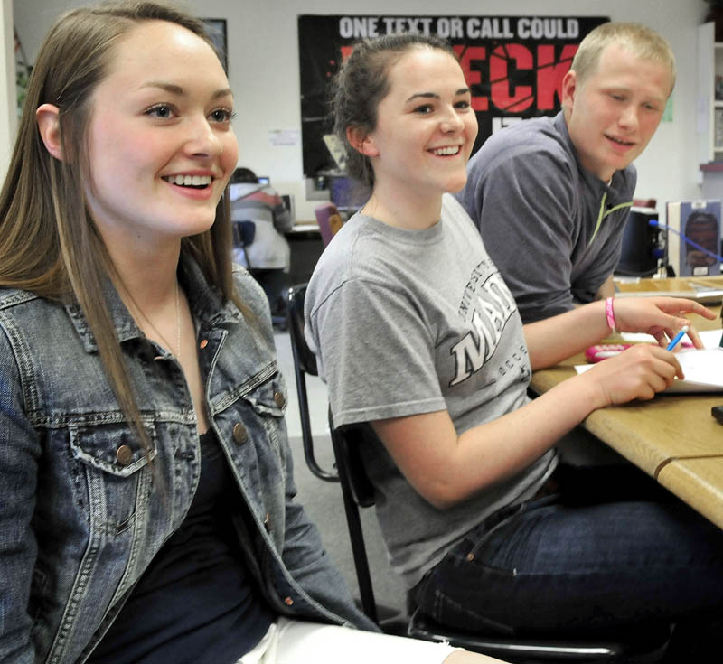 Erskine Academy students react happily to hearing the school received a grade B by the State Department of Education on Wednesday. From left are Taylor Bailey, Abigail Glidden and Jared Gartley.