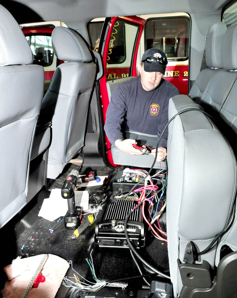 Lt. Tim Hardy connects radio equipment inside a new squad truck being assembled at the Farmington Fire Department. Several department personnel donated time and expertise to lower the cost of the new vehicle.