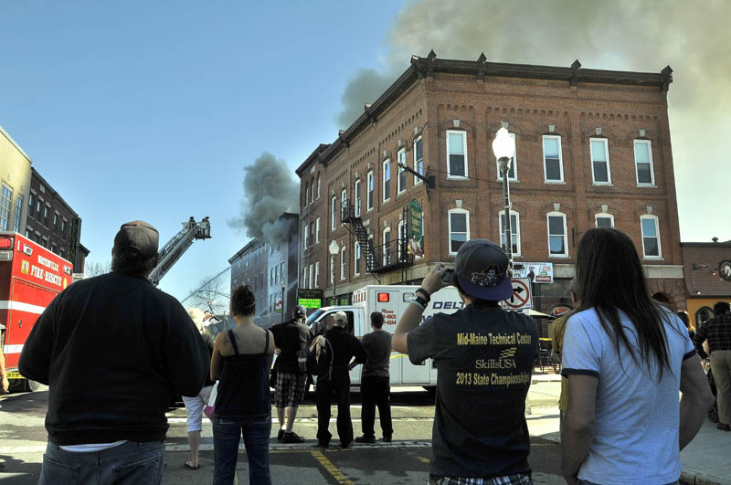 Crowds gather on Main Street in downtown Waterville on Friday afternoon as a building burns between Spring and Silver streets.