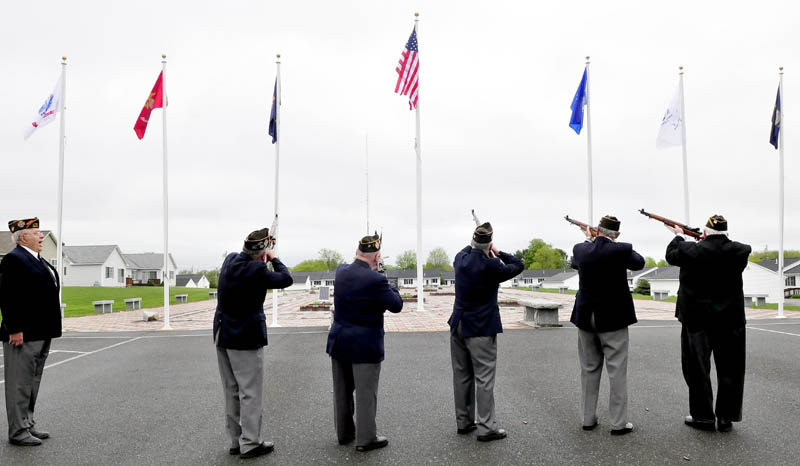 The Winslow VFW 8835 color guard does a 21-gun salute following the raising of a large American flag during a ceremony at the Central Maine Veterans Memorial Park in Winslow on Thursday. The organization donated six armed services flags and two-dozen smaller American flags for flower pots.