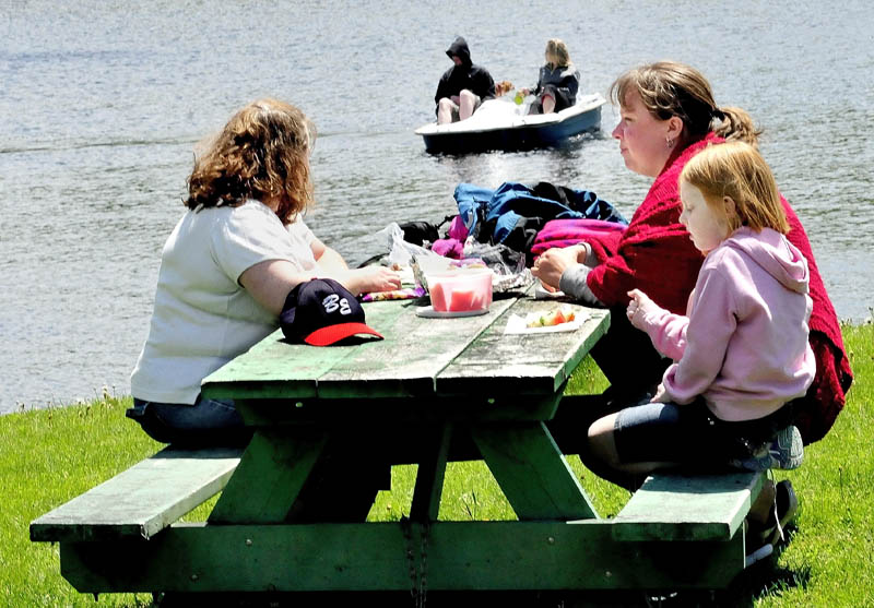 The sun finally poked out after a week of dreary rain and clouds bringing picnickers and boaters to Messalonskee Lake in Oakland on Monday. Enjoying a lunch outside are, from left, Chrystal Dakin, Kim Corriveau and MaryRuth Dakin. "It was starting to get depressing," Corriveau said, referring to the damp weather.