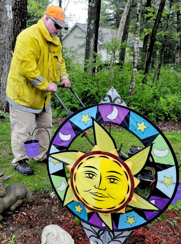 The only sun to be found on a rainy Sunday was an ornament in a garden at Pauline Tuttle's home in Clinton, as her son-in-law, Michael Flanders worked. Several other relatives offered to do outside chores for Tuttle as a Mother's Day gift.