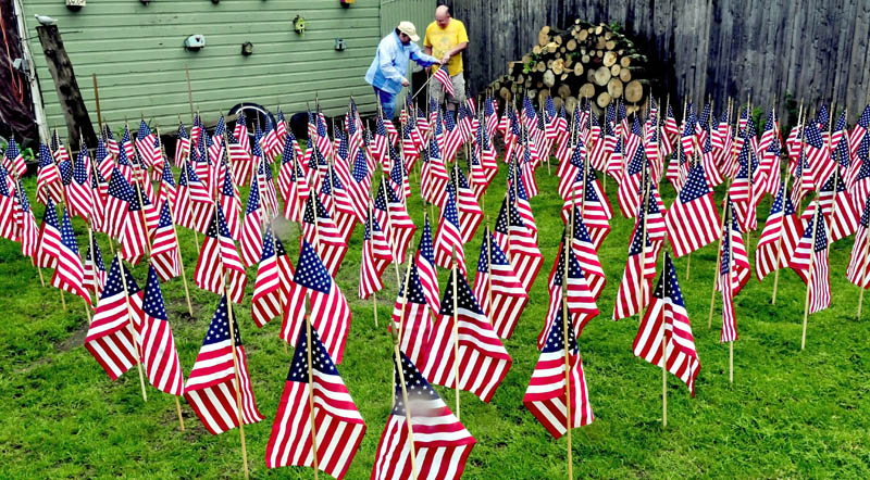 Heather and Ralph Merrow on Sunday set out to dry, at their home in Waterville, some of the 500 American flags that were left over after members of Boy Scout Troop 436 placed them on graves of veterans at the Maine Veterans Cemetery in Augusta recently. The flags will be stored until needed again.