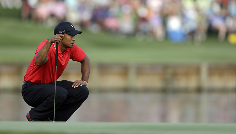 Tiger Woods looks at his putt on the 17th green during the final round of The Players Championship at TPC Sawgrass in Ponte Vedra Beach, Fla. He made par while his longtime rival Sergio Garcia hit two balls into the water before the green to fall out of contention.