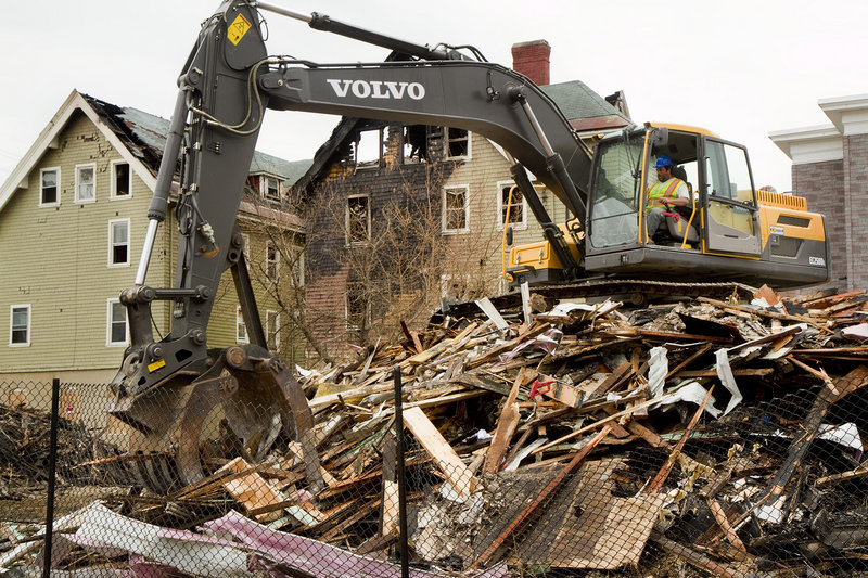 A demolition crew cleans up rubble from the Blake Street fire in Lewiston on Thursday.
