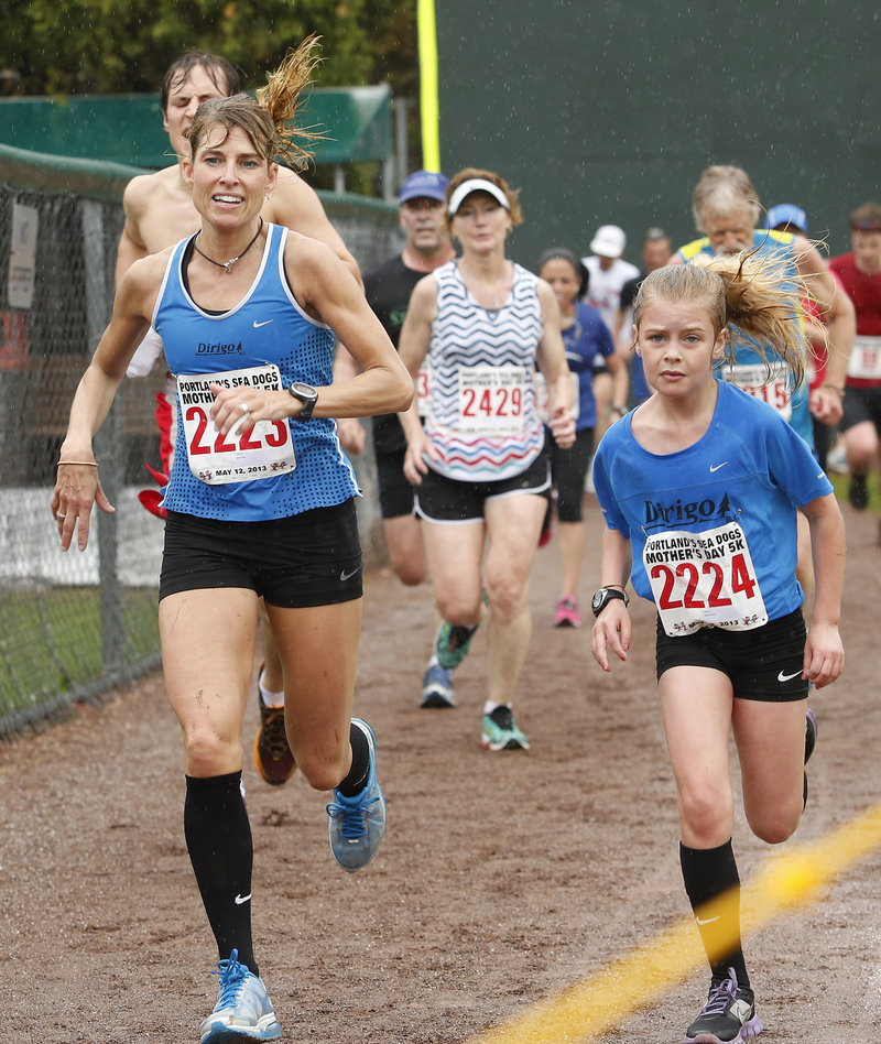 The mother and daughter team of Sheri and Karley Piers nears the finish line, daughter first, who ran best among the 14-and-under girls, finishing in 23:48, a few strides ahead of her mom.