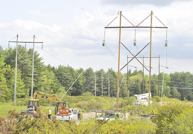 Hawkeye crew members adjust the tension on newly installed utility poles and wires near Smutty Lane in Saco on Monday, May 20, 2013.
