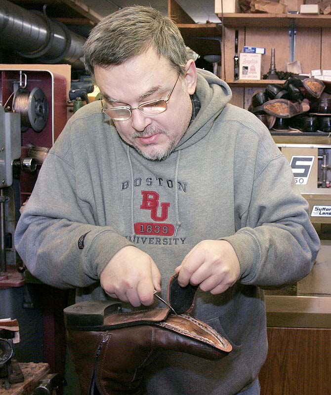 Charles Scontras replaces part of the sole of a boot while working in his shop, the Saco Shoe and Leather Hospital, in 2006. Scontras died in the fire after Saturday’s standoff.
