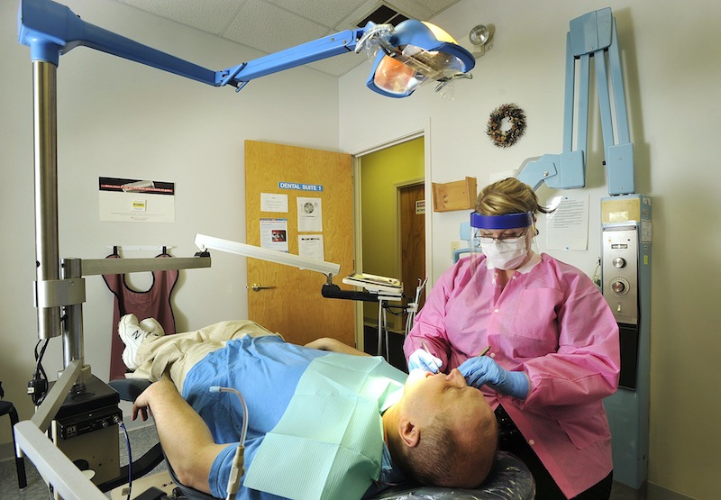 In this January 2013 file photo, Dental hygienist Torey Richard conducts a teeth cleaning for patient Rick Hagan at Clinical Services in Portland. The Democratic-led Maine House gave initial approval to a bill Tuesday that would create a new category of dental hygienists, which supporters say would provide more people access to affordable dental care.
