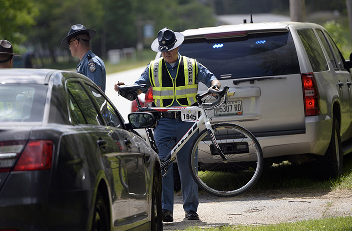 State police move a bike that was involved in a fatal crash in Hanover on Friday. David LeClair, 23, of Watertown, Mass., was struck by a tractor-trailer just miles from the starting point of the annual Trek Across Maine cycling event.