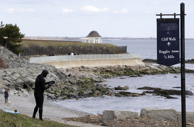 A surfer stands at the coast in Newport, R.I., in March. Scientists say tsunami-like conditions were recorded along part of the East Coast in June. The highest peak amplitude was recorded in Newport.