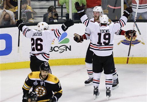 Chicago Blackhawks left wing Bryan Bickell, center, celebrates his goal with Chicago Blackhawks center Jonathan Toews (19) and Chicago Blackhawks center Michal Handzus (26), of Slovakia, during the third period in Game 6 of the NHL hockey Stanley Cup Finals against the Boston Bruins, Monday, June 24, 2013, in Boston. (AP Photo/Charles Krupa) TD Garden