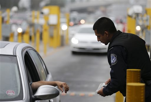 A Customs and Border Protection officer speaks to a driver at the San Ysidro port of entry on Thursday in San Diego.