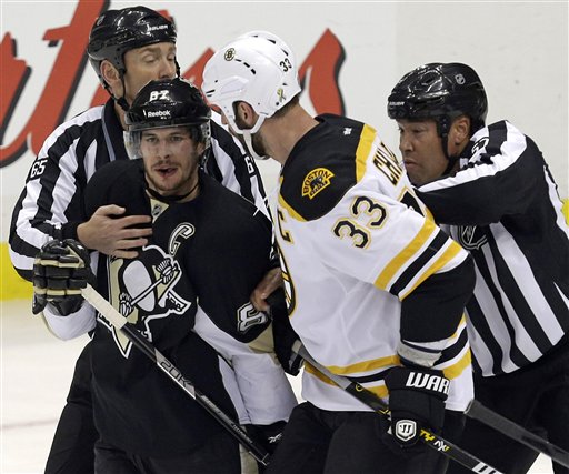 Linesmen separate Pittsburgh Penguins' Sidney Crosby (87) and Boston Bruins' Zdeno Chara (33) during the first period of Game 1 in an NHL hockey Stanley Cup Eastern Conference finals in Pittsburgh, Saturday, June 1, 2013. (AP Photo/Gene J. Puskar)
