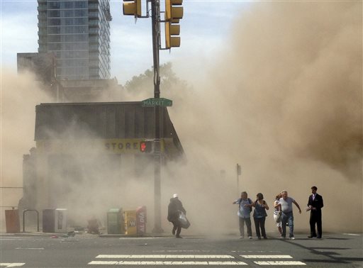 In this photo provided by Jordan McLaughlin, a dust cloud rises as people run from the scene of a building collapse on the edge of downtown Philadelphia on Wednesday.