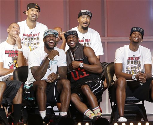 Miami Heat players laugh as they watch highlights of center Chris Bosh, right, Monday, June 24, 2013, during a celebration for season ticket holders at the American Airlines Arena in Miami. Other players from left are: Shane Battier, Juwan Howard, LeBron James, Dwyane Wade and Rashard Lewis. The Heat defeated the San Antonio Spurs 95-88 in Game 7 to win their second straight NBA championship.