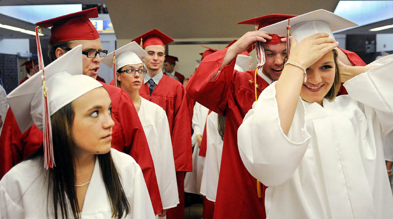 Cony High School seniors hastily adjust their caps while marching into graduation Sunday in Augusta.