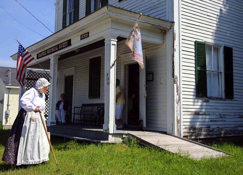 Dale Potter Clark walks in front of the Readfield Historical Society while portraying Releaf Savage Gordon, an early settler of the community, on Sunday, during the society's first open house of the season.
