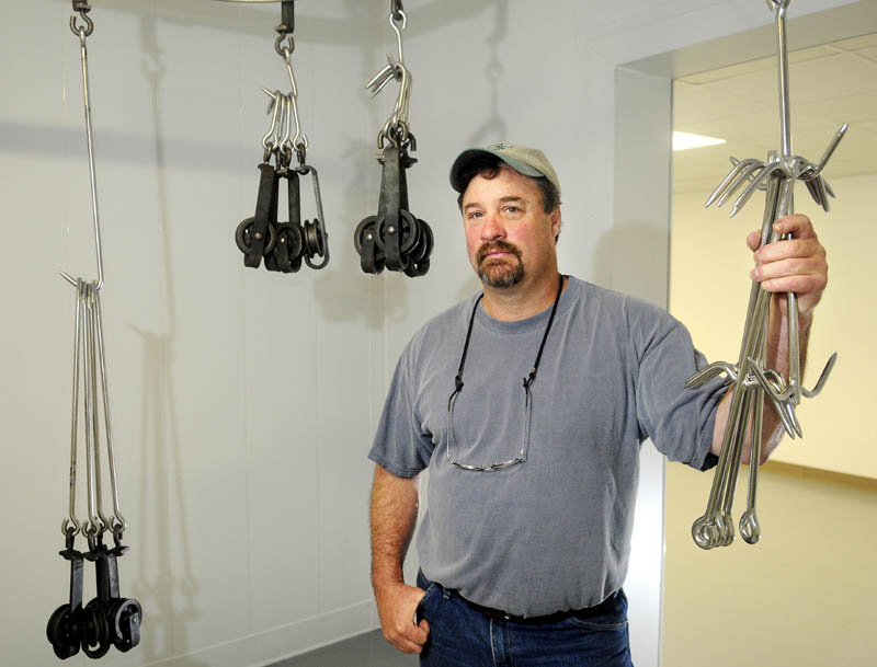 Craig Linke holds onto meat hooks Thursday at Northeast Meats, the new meat processing plant on Brunswick Avenue in Gardiner he is opening. Northeast Meats will prepare Maine animals for consumption.