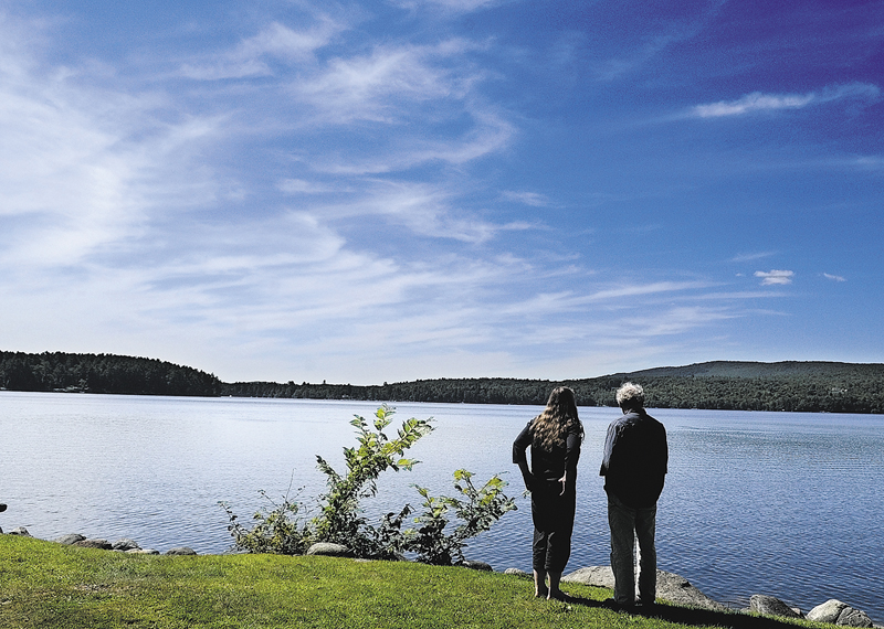 Joanne Moesswild and Paul McKinney, both of Belfast, look out at Long Pond from the picnic area behind Day's Store on a warm sunny Wednesday afternoon in Belgrade Lakes.