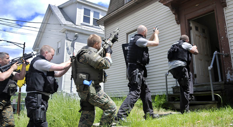 Police officers from across New England enter a building on Water Street in Augusta on Tuesday during the basic Special Weapons and Tactics training school being taught this week by the National Tactical Officers Association. The annual program is being attended by 13 police officers from across New England, according to Augusta Police Chief Robert Gregoire, to learn about advanced safety and apprehension techniques. This is third time the class, taught by retired Tulsa, Okla, police officer Bill Yelton, has been sponsored by the city of Augusta, Gregoire said.