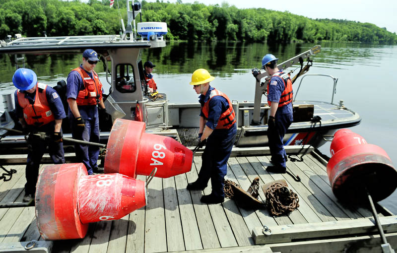 U.S. Coast Guardsmen unload buoys Thursday at the Hallowell boat landing on the Kennebec River. The crew from the Coast Guard's Aids to Navigation station in Portland reset multiple buoys that were displaced by recent high water in the river.