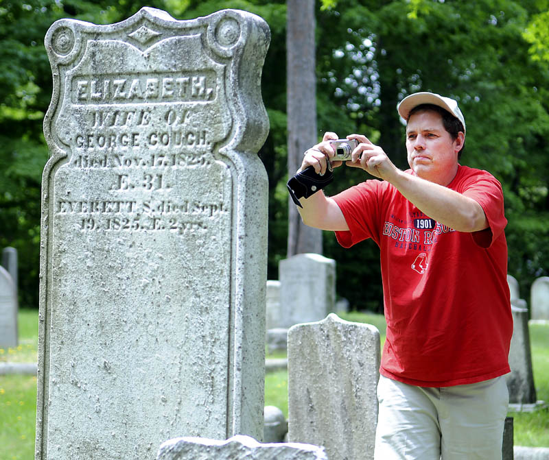 Brad Cushman photographs a relative's gravestone Monday at the Hallowell Cemetery. Cushman and his parents drove up from Burlington, Mass., to examine four Maine cemeteries which contain the remains of relatives.
