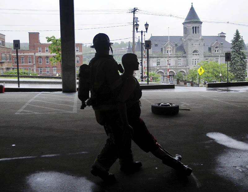 Brian Ackley, of Topsham, drags a life-size mannequin through a parking garage in Augusta on Tuesday during a physical agility test for prospective Augusta firefighters. A dozen candidates were tested on their dexterity, firefighting and emergency medical skills before being interviewed for potential openings, according to Deputy Fire Chief David Groder.