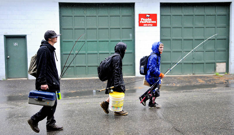 Nick Crocker, 16, left, Dylan Young, 13, and T.J. Ladd, 20, walk to their Augusta homes in the rain Tuesday after a fishing trip to the banks of the Kennebec River. The trio casts lines almost every day "except for thunder and lightning," Ladd said.