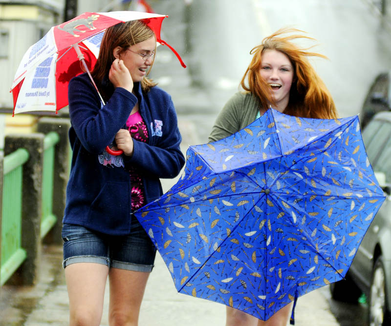 Olivia Turner collects her deflated umbrella Tuesday while walking to lunch with Devon Hall in Gardiner. The Gardiner Area High School students were celebrating their last day of school for the year with a stroll through the rain. Rain and brisk winds are forecast to persist for the rest of the week.