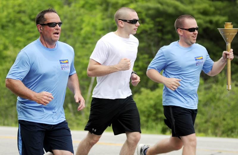 Parole and Probation officer Mark Fortin, left, and Gardiner Police officer Chris Balestra, center, and Gardiner Police Det. Mike Durham run down Route 201 in Gardiner Thursday while participating in the law enforcement torch run to benefit the Maine Special Olympics. Police from across Maine are escorting the torch from Kittery to the University of Maine in Orono to raise funds for the annual competition for people with special needs. Fortin and the Gardiner officers collected the torch at the Richmond line from Johanna and Norman Stickney and handed it off to Hallowell Police Chief Eric Nason in Farmingdale who carried it to Augusta, where the police ran with it Vassalboro. The run should take three days.
