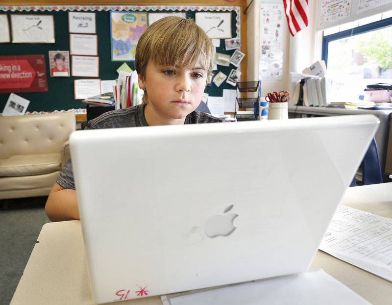 Sixth-grader Cole McGhie works on an Apple laptop computer May 27 during class at King Middle School in Portland. Microsoft and Hewlett Packard are making strong pitches to win Maine's public-school laptops business.