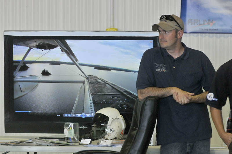 Matt Sylvester of Airlink LLC, a pilot training school at Robert LaFleur Municipal Airport, offers free training simulator rides at the newly renovated airport in Waterville, during a Mid-Maine Chamber of Commerce Business After Hours event on Wednesday.