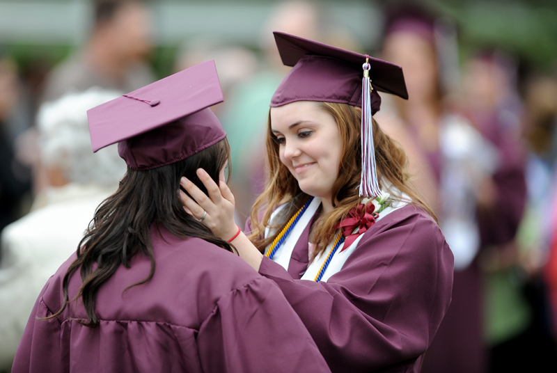 Elizabeth Fitzmaurice, right, has a moment with her friend, Leah Breen, before Nokomis High School's commencement ceremonies in Newport on Friday.