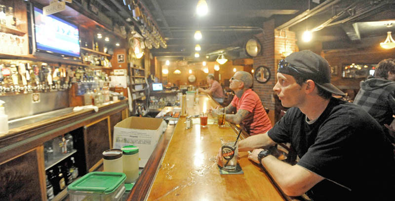Deon Bennett, 36, far right, sips on a drink as he waits for his lunch at Mainely Brews on Main Street in Waterville on Friday. The Legislature's budgeting committee on Friday proposed a 1 percent increase of the meals and lodging tax, and a 0.5 percent increase of the sales tax.