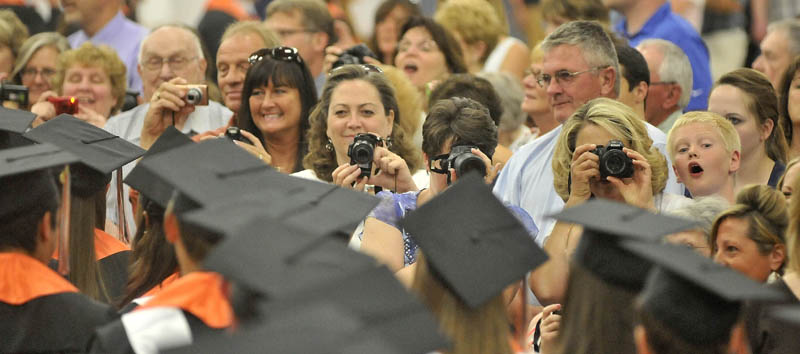 Friends and family take photos of the Winslow High School class of 2013 as they march in to Wadsworth Gymnasium during commencement ceremonies at Colby College in Waterville on Wednesday.