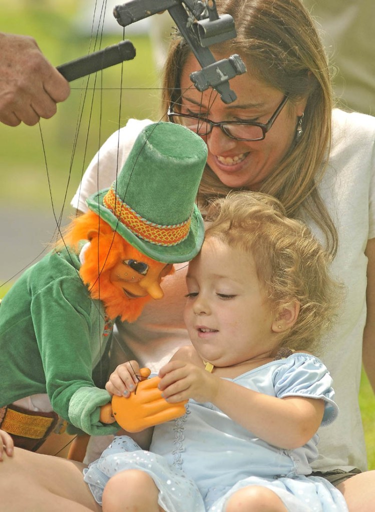 Meadow Bean, 2, and her mother, Josie Bean, enjoy puppeteer Dan Grady's leprechaun marionette at the first Summer Solstice Celebration in downtown Farmington on Saturday.