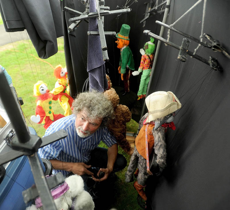 Puppeteer Dan Grady prepares his marionettes for a series of three shows at Meeting House Park, during the first Summer Solstice Celebration in downtown Farmington on Saturday.