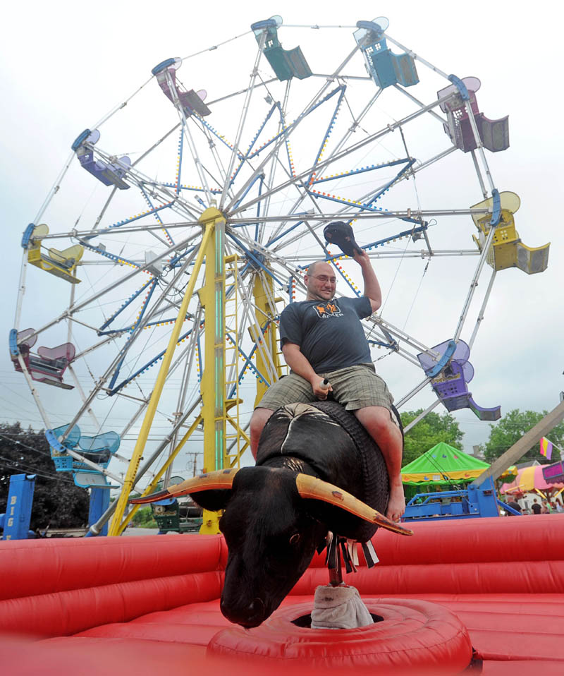 Dan Cahoon, of Oakland, rides the mechanical bull at the Water Street carnival during the Fairfield Days Community Festival on Saturday.