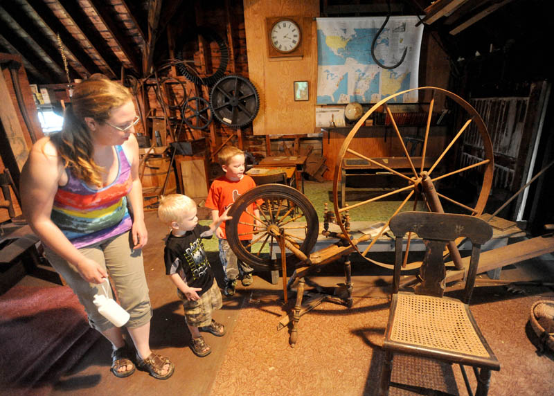 Nikkia Finnemore, 30, left, and her children, Kristpher, 3, center, and Benjamin, 5, right, tour the barn at the Cotton-Smith House on High Street in Fairfield during the Fairfield Days Community Festival on Saturday.