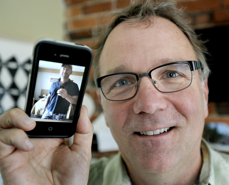Chris Kast, a brand strategist at The Brand Co. in Portland, is seen here with a photo of his husband Byron Bartlett on Wednesday, June 26, 2013. They were two of many local residents to celebrate the Supreme Court's ruling.