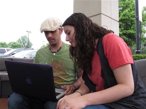 Reem Dahir takes a peek at fiancee Abraham Ismail's laptop as they chat at a Starbucks cafe in Raleigh, N.C. on Thursday. The young couple understands the need for surveillance to prevent terrorist attacks, but they worry the government went too far by gathering secreting gathering phone data from millions of Americans.