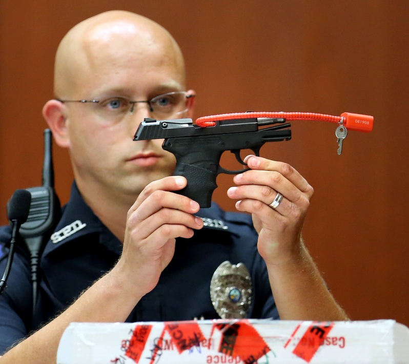 Sanford, Fla., police Officer Timothy Smith holds up the gun that was used to kill Trayvon Martin, while testifying in the George Zimmerman trial in Seminole circuit court in Sanford, Fla., on Friday.
