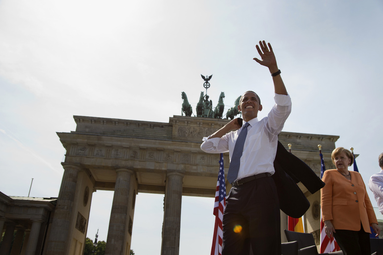 President Barack Obama, accompanied by German Chancellor Angela Merkel, waves to the crowd after speaking at the Brandenburg Gate in Berlin on Wednesday.