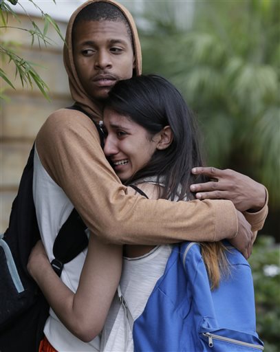 A weeping woman is comforted after being escorted off campus as police swarm Santa Monica City College, where a gunman shot numerous people Friday.