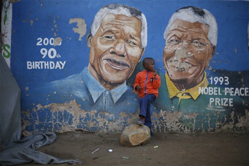 Hussein Gallo, 7, stands by a mural of Nelson Mandela in the Soweto township in Johannesburg, South Africa, on Saturday. Former South African President Nelson Mandela is in "serious but stable" condition after being taken to a hospital to be treated for a lung infection, the government said Saturday, prompting an outpouring of concern from admirers of a man who helped to end white racist rule.