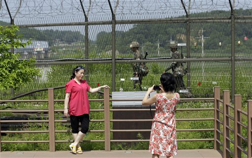 Visitors take souvenir photos as military soldiers patrol at the Imjingak Pavilion near the border village of Panmunjom, which has separated the two Koreas since the Korean War, in Paju, north of Seoul, South Korea, Sunday.