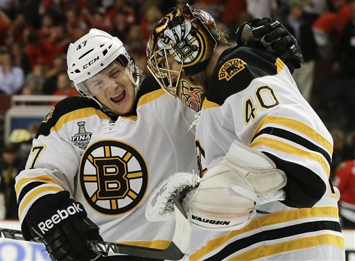 Boston Bruins defenseman Torey Krug (47) celebrates with goalie Tuukka Rask (40) after the Bruins scored a goal against the Chicago Blackhawks in sudden death overtime during Game 2 of the NHL hockey Stanley Cup Finals, Saturday, June 15, 2013, in Chicago. The Bruins won 2-1. (AP Photo/Nam Y. Huh)